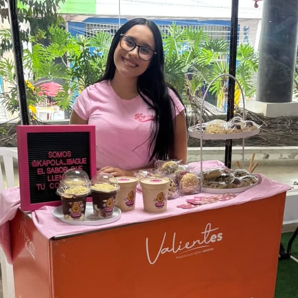 Laura Lasso sonriendo en el stand de Kapola en la feria Mujeres que abren caminos